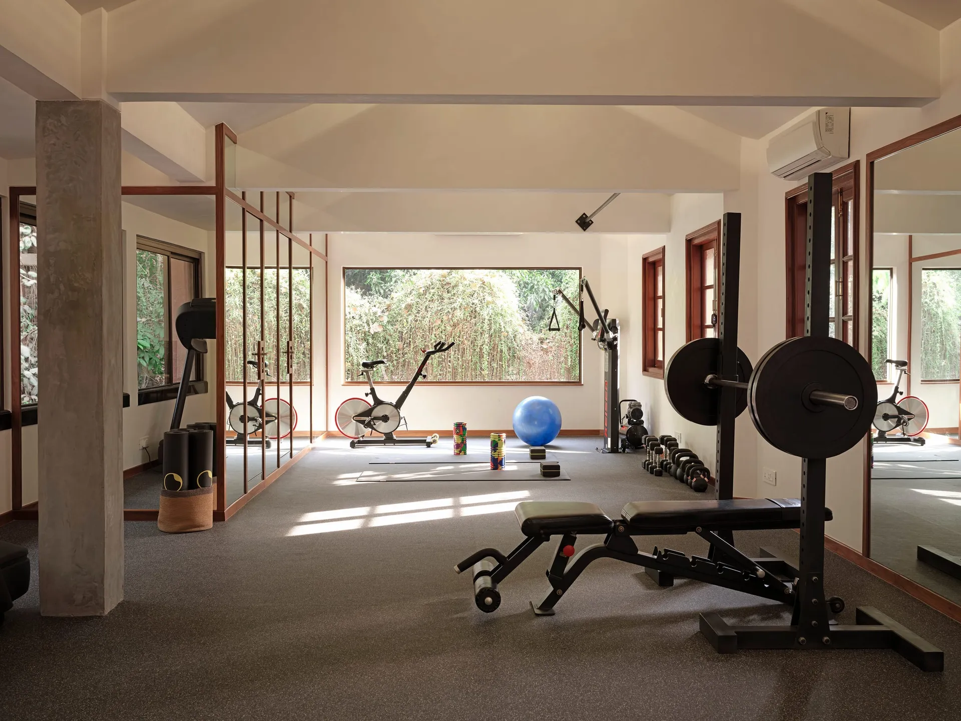 The Soleus studio floor, with free weights, a squat rack, and spin bikes facing a bamboo garden.